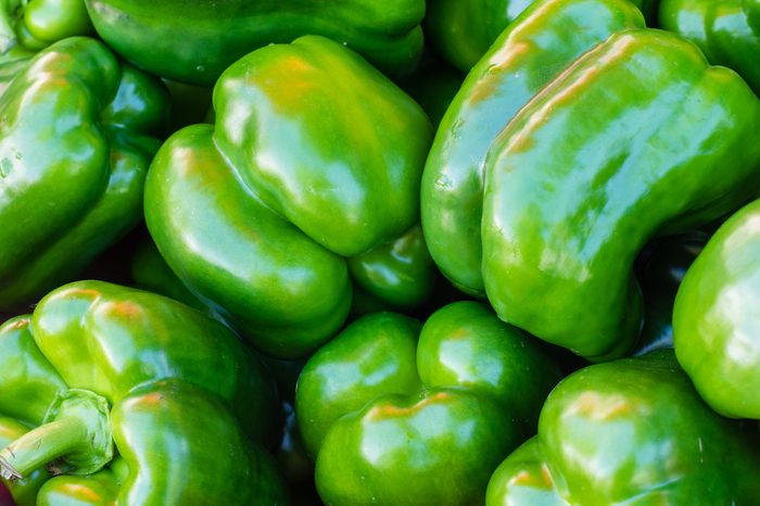 Freshly picked green bell peppers on display at the market