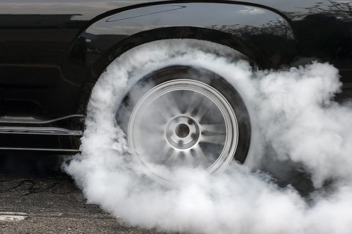 Drag racing car burns rubber off its tires in preparation for the race