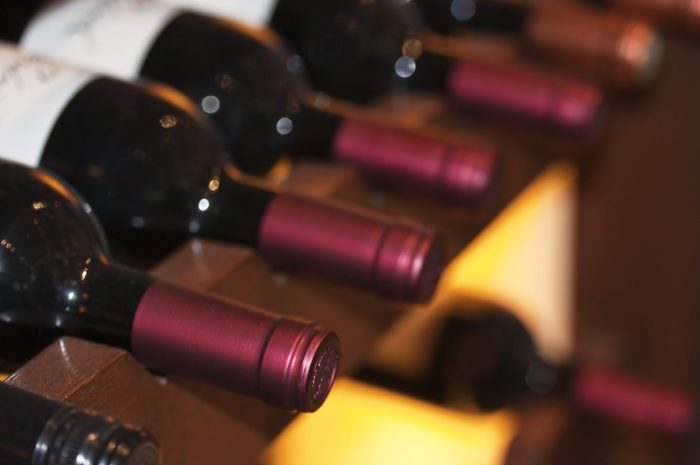 Bottles of red wine on a wooden shelf