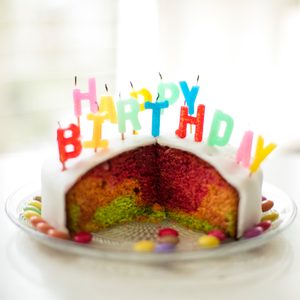 Cake with rainbow layers, topped with 