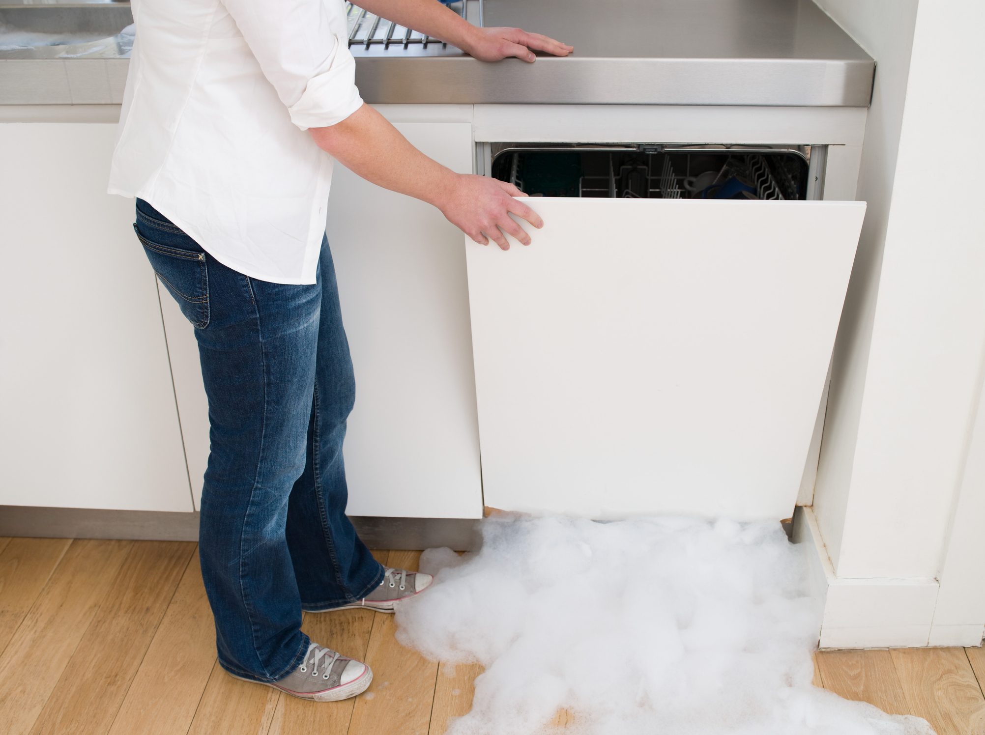 Woman opening a leaking dishwasher