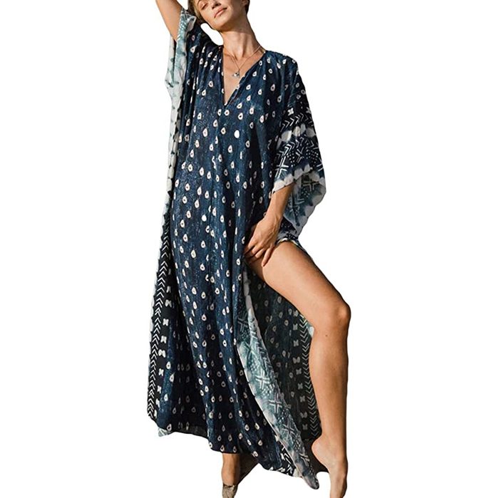 Kaftan dress flows gracefully, showcasing geometric patterns, worn by individual posing confidently, against a plain white background.