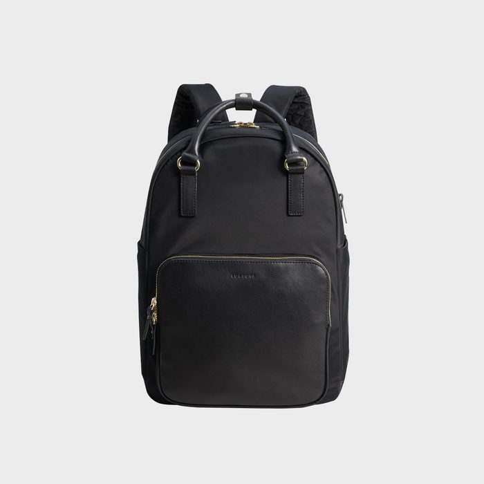 A sleek black backpack with gold zippers and leather accents, displayed against a plain gray background. 