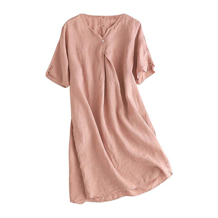 A pink, loose-fitting dress hangs on a hanger, displayed against a plain white background.