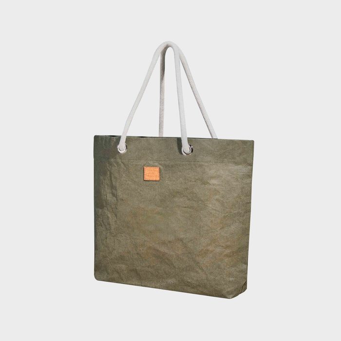 Green tote bag hangs with rope handles, small patch on front, against a plain white background.