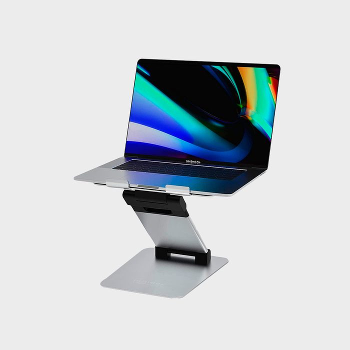 Laptop resting on silver adjustable stand, displaying a vibrant, multicolored screen. The gray background provides a neutral context.