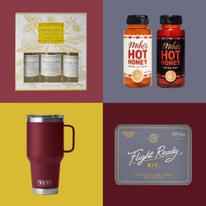Gift set on red displays Meyer lemon toiletries; two hot honey bottles on gray; burgundy YETI mug on yellow; Flight Ready Kit on dark red.