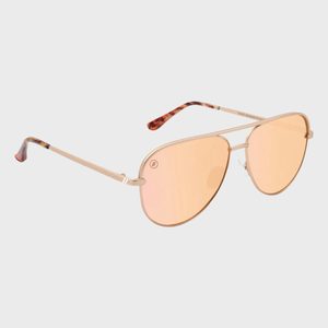 Sunglasses with rose-tinted aviator lenses and gold frames, resting against a plain pale background.