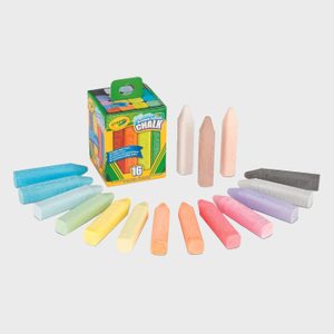 Colorful chalk pieces lie in a semicircle around an open Crayola box on a plain background. Box displays 