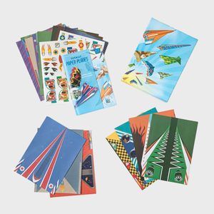 Paper plane kits arranged with colorful designs, includes instruction booklet titled 