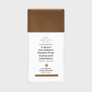 White bottle with brown cap displaying text about Drunk Elephant D-Bronzi Anti-Pollution Sunshine Drops. Contains cocoa extract and platinum peptides, 30 ml.