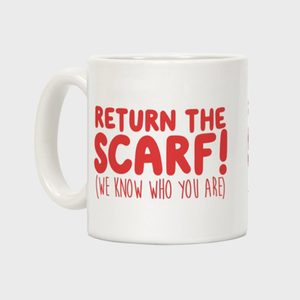 A white mug displays red text, 