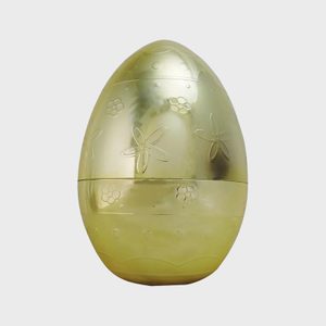 Golden egg displays engraved floral patterns, set against a plain, light background.