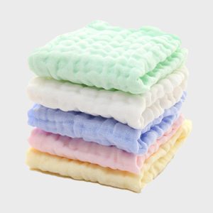 Stacked pastel washcloths lying neatly on top of each other against a plain background.