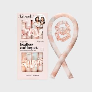 Hair curling set sits beside its packaging, featuring soft pink satin material, designed for heatless hair styling. The box showcases product information and images.