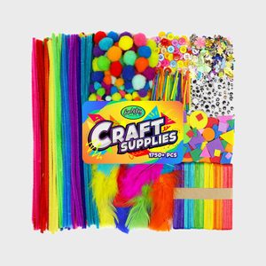 Assorted colorful craft supplies spread out, including pipe cleaners, pom-poms, buttons, sequins, feathers, sticks, under a labeled 