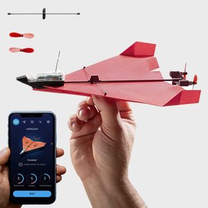 Paper airplane held by hand, controlled by a smartphone app, with propeller and structural parts displayed above on a plain background.