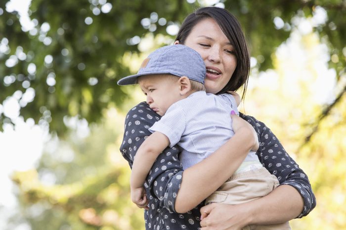 Mixed race mother comforting crying son outdoors