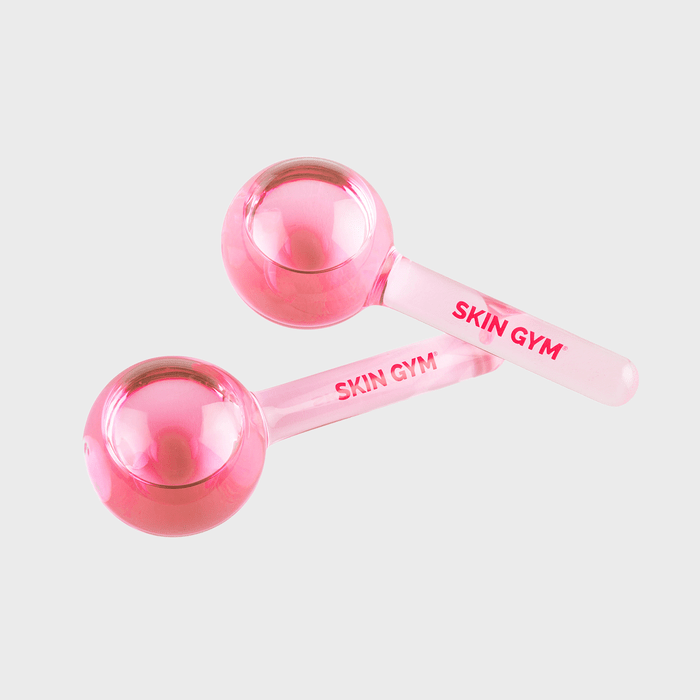 Pink facial globes rest side by side, inscribed with 