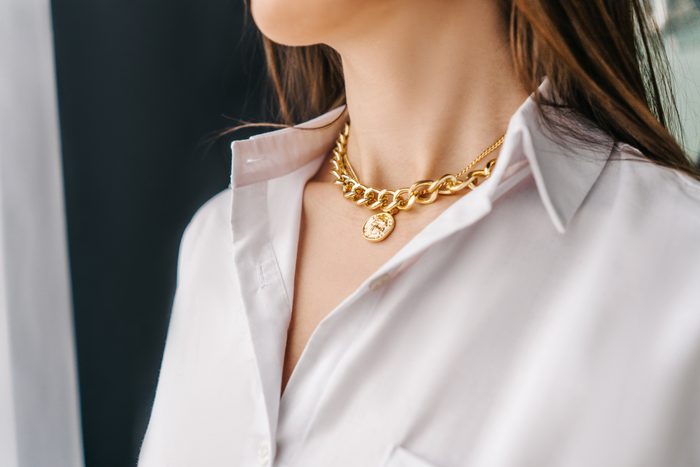 Silver bijouterie chain on woman neck. Close-up.