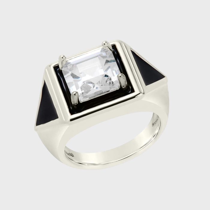 A silver ring showcases a large rectangular gemstone, set in a modern design with black triangular accents on each side, against a plain background.