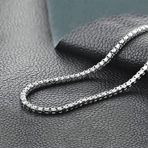 A diamond-studded bracelet rests on textured black leather, glistening under soft lighting.