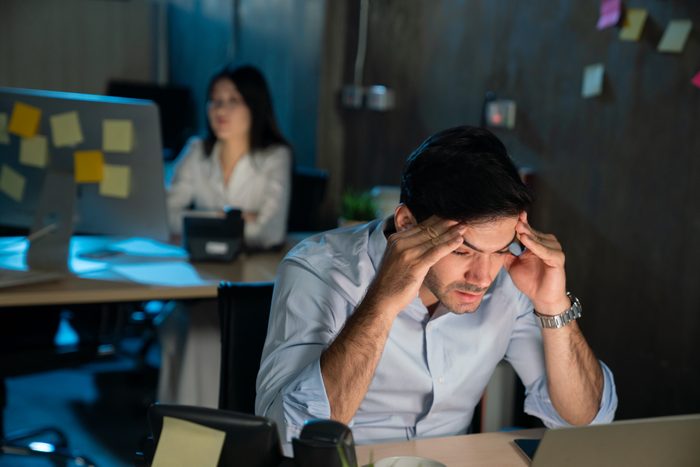 Shot of a young businessman experiencing stress during a late night at work