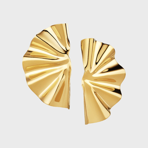 Two gold, fan-like shapes positioned symmetrically against a plain white background, with a rippled, reflective surface.