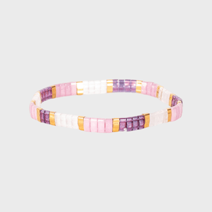 Bracelet featuring alternating pink, purple, white, and gold square beads, lying flat on a plain white background.