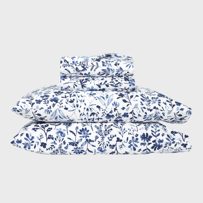 A stack of floral-patterned bedding sits neatly against a plain white background.
