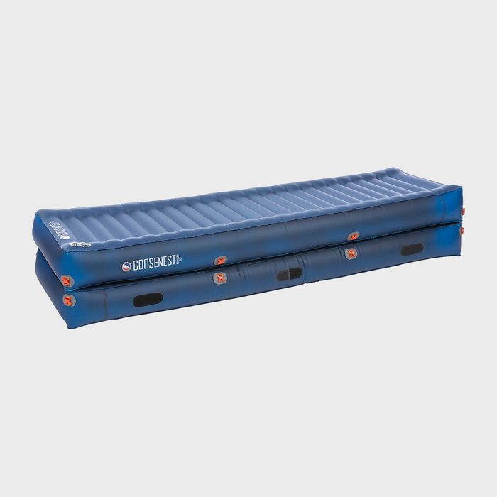 Blue inflatable mattress rests flat, featuring gray seams and orange valves, set against a plain background. Text reads 