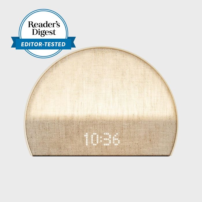 Clock displays 10:34 on a woven fabric surface, half-circle shape; has 