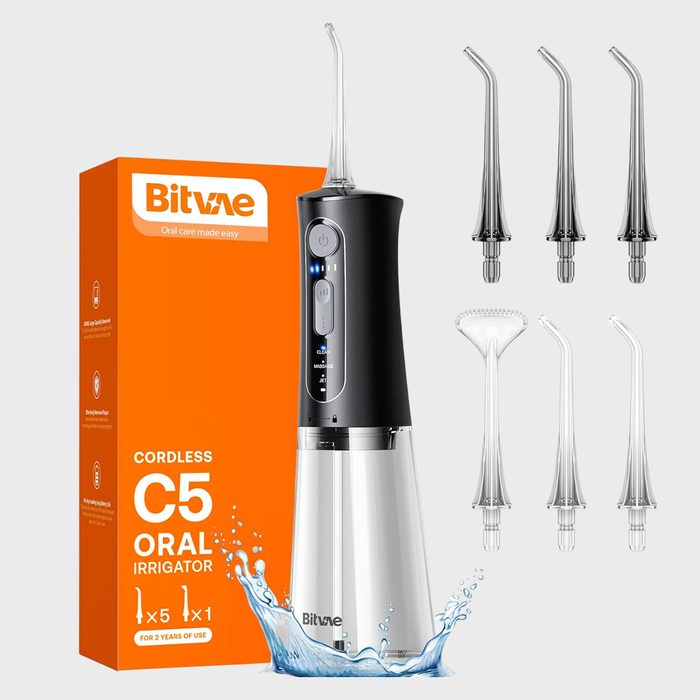 Water flosser displayed with five nozzle attachments, beside an orange box labeled 