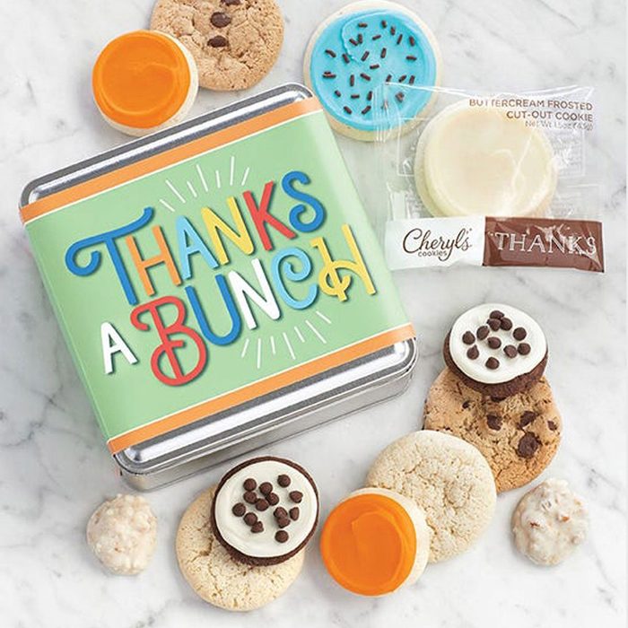 Tin displays â€œThanks a Bunch,â€ surrounded by assorted cookies on a marble surface, including packaged frosted cut-out cookie from Cheryl's Cookies.