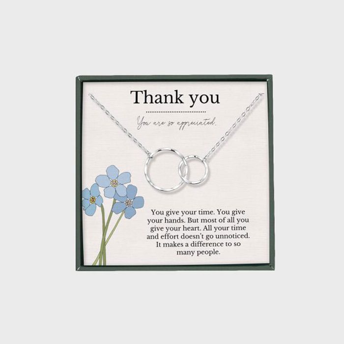 Necklace displays interlocking silver rings, centered on a background with text thanking for effort and featuring blue flowers.