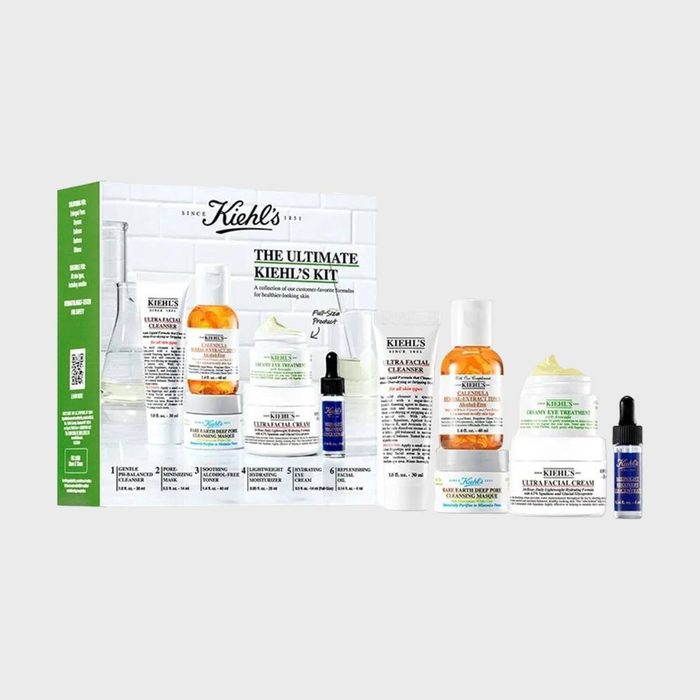Skincare products arranged beside a branded box featuring Kiehl's label; includes bottles, tubes, and jars on a plain background.