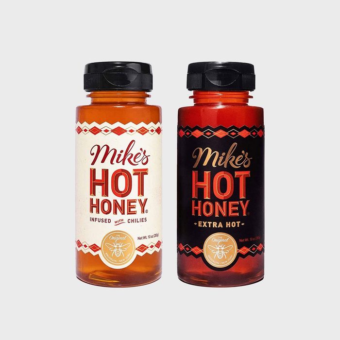Two bottles of Mike's Hot Honey stand upright, labeled 