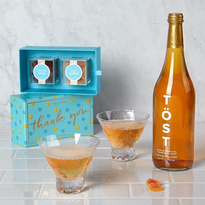 Box displays candy; two glasses hold amber beverage; bottle labeled 