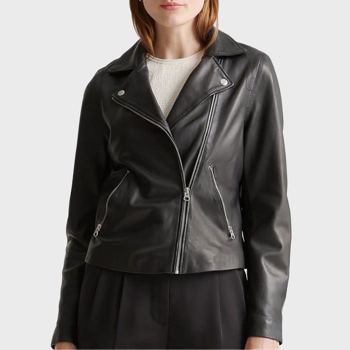Jacket worn zipped, with shiny silver zippers and black material, in a minimal indoor setting.