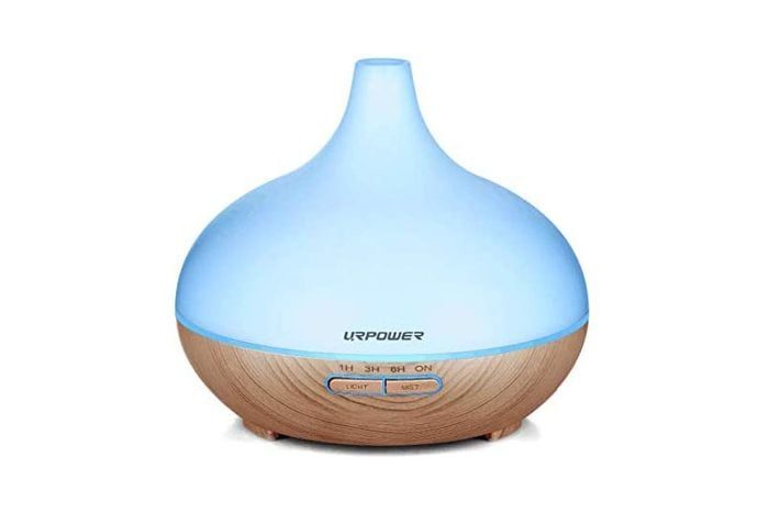 A round, blue and wood-textured diffuser releases mist, placed on a white background. Text reads 