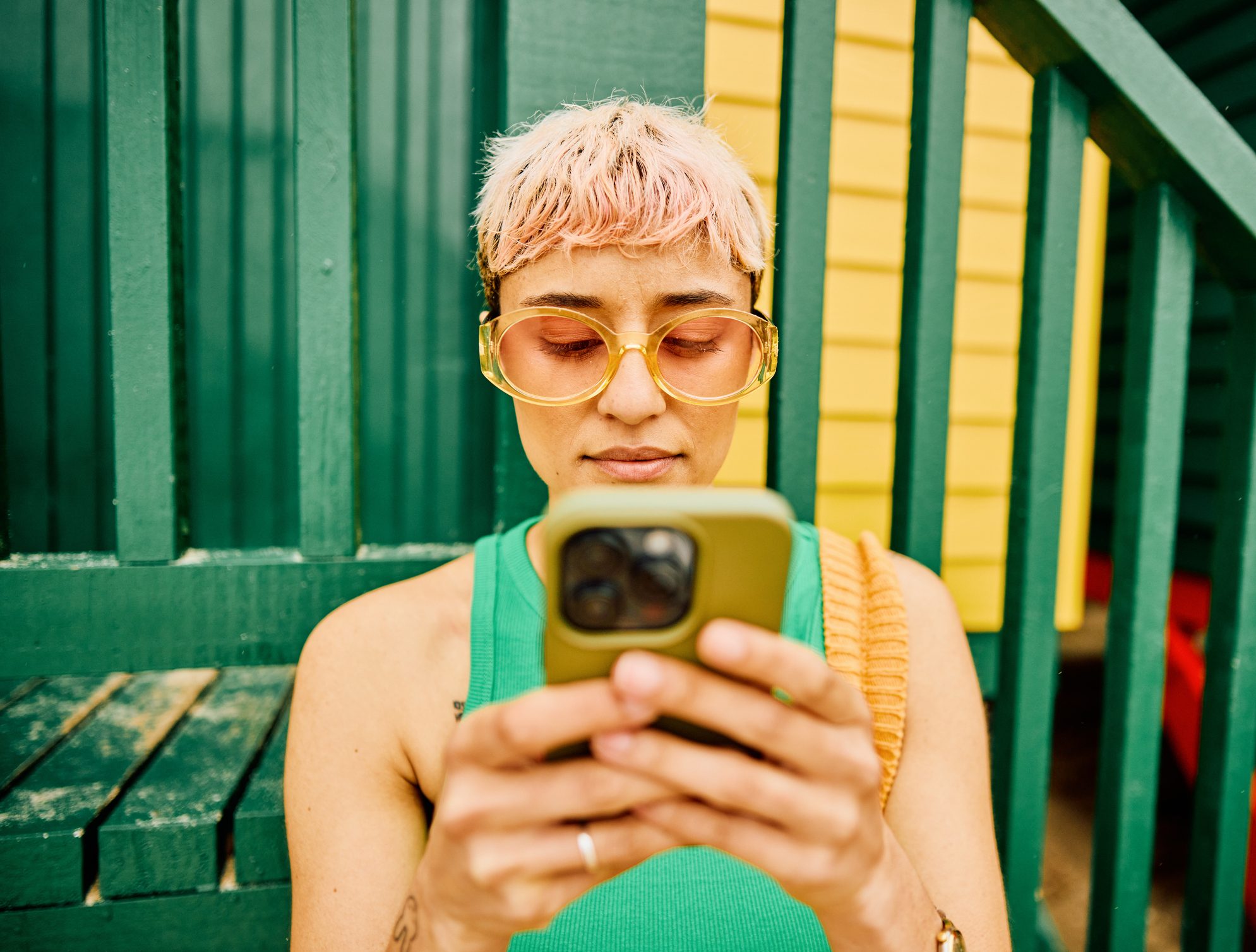 Young person with orange glasses using their phone
